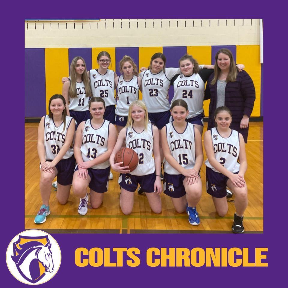 10 young ladies in white jerseys that say "Colts" with their coach.