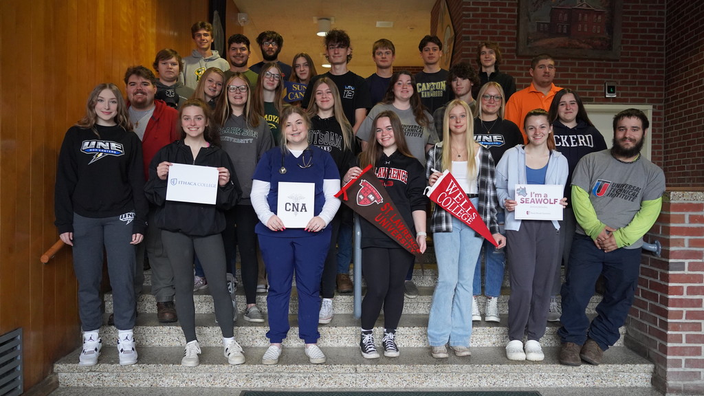 Seniors stand with their college and after-graduation plans in the auditorium lobby